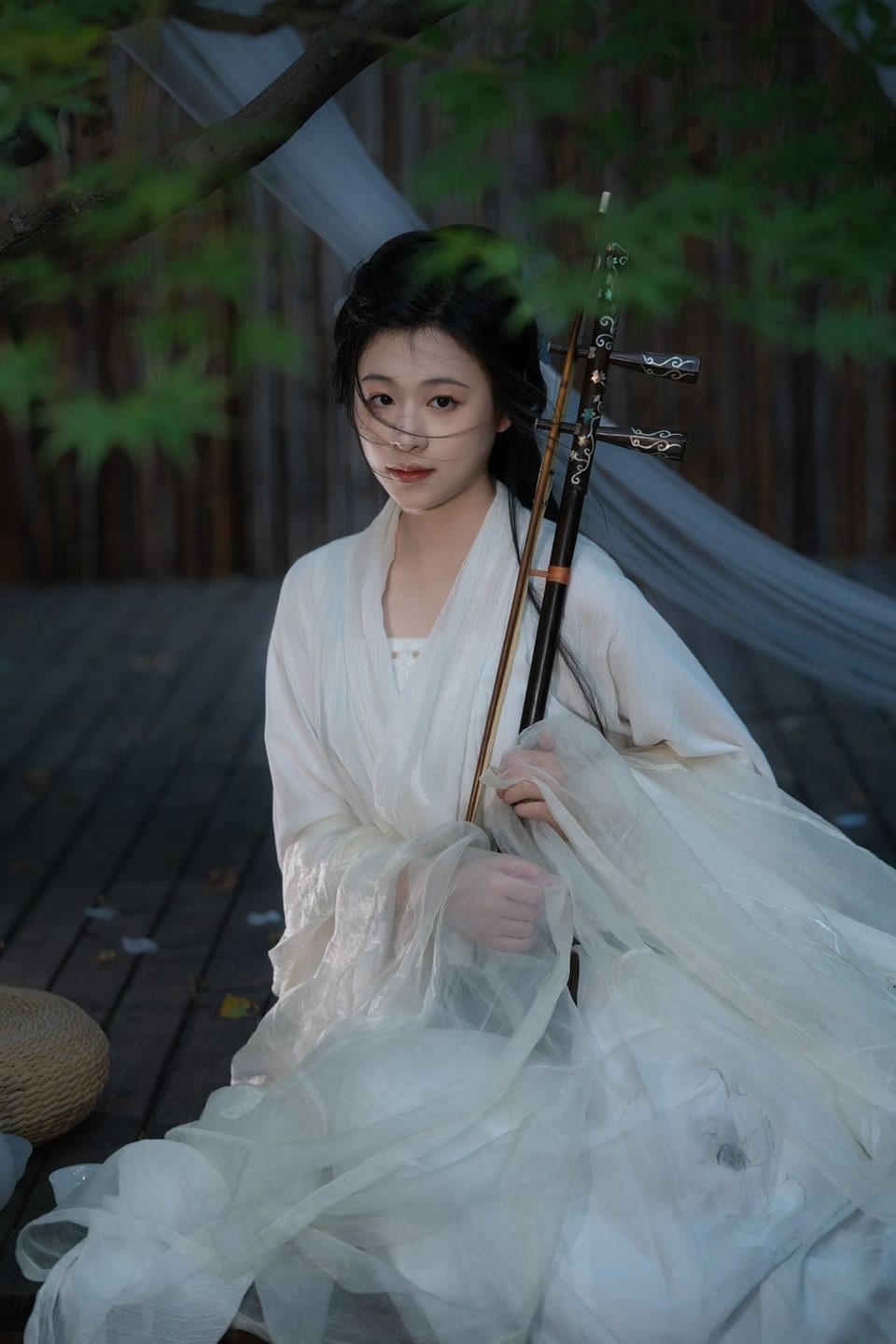 Lu Shujie in white hanfu, holding her erhu in a garden